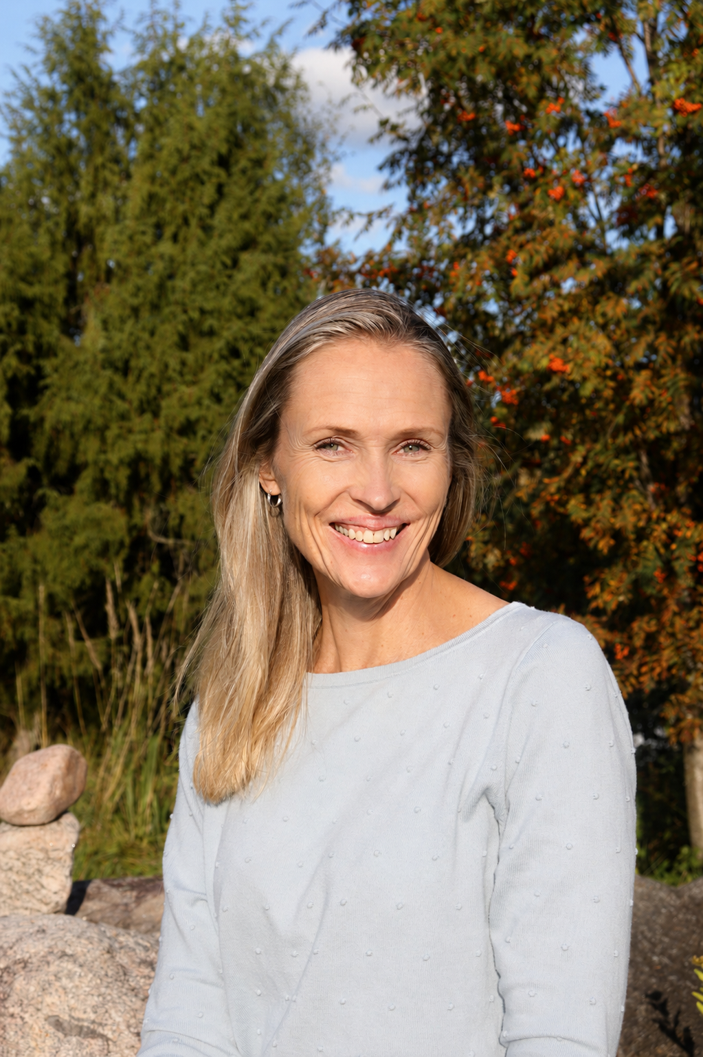 Hymyilevä Merja Valkonen-Hernandez luonnon keskellä